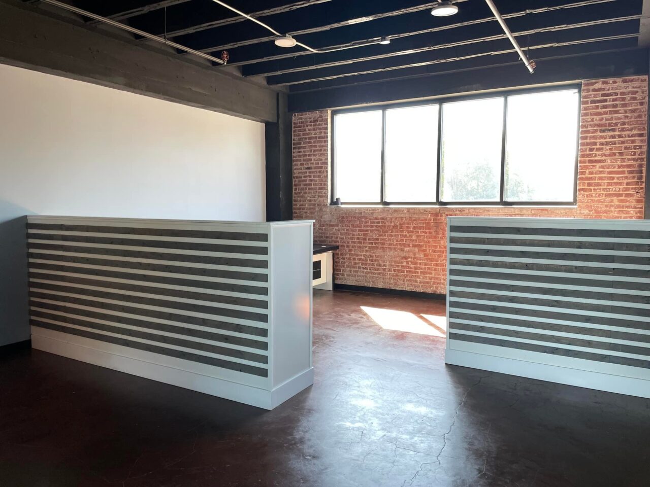 Common workspace with slatted partitions and exposed brick
